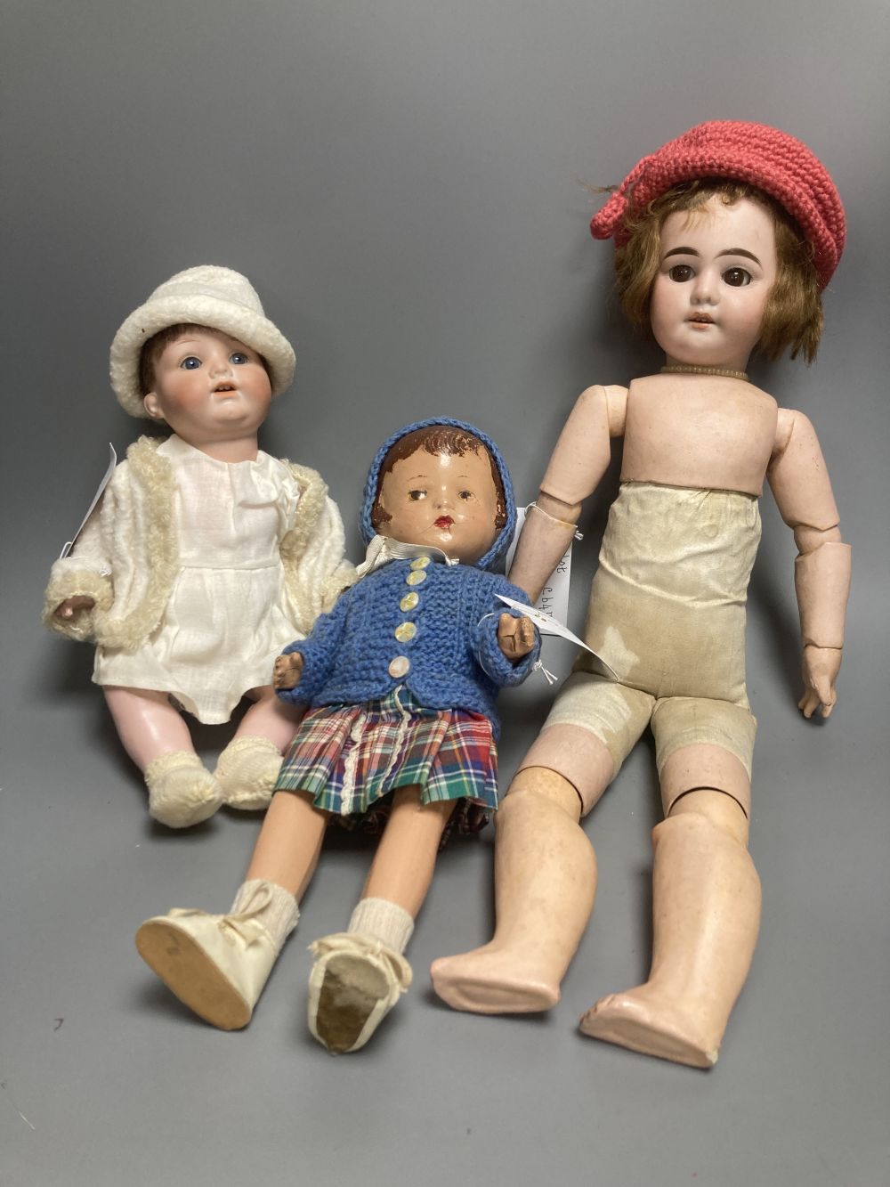 An Armand Marseille bisque boy doll, mould 990 with fixed glass eyes, 30cm, a bisque doll with jointed composition body, 47cm and a pai